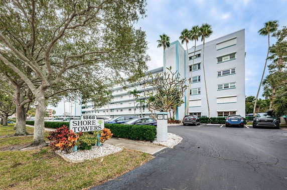 Front view of a multi-story apartment building with a sign labeled 'Shore Towers'.