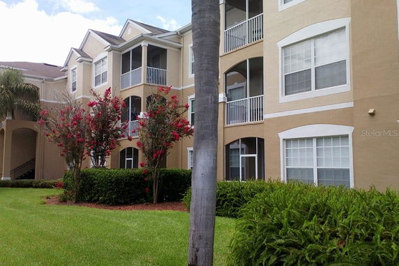 Front view of a multi-story residential building with balconies and large windows.