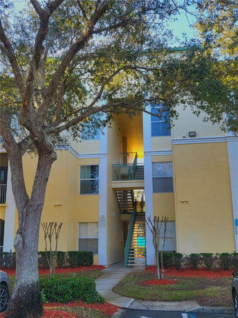 Front view of a multi-story building with external staircase.