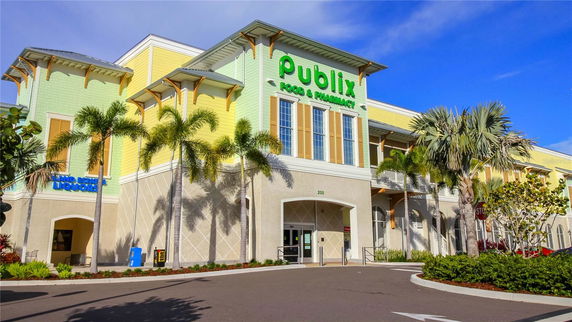 Front view of a two-story commercial building with a vibrant facade and palm trees.