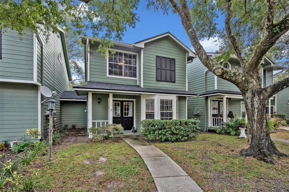 Front view of a two-story house with green siding and white trim.