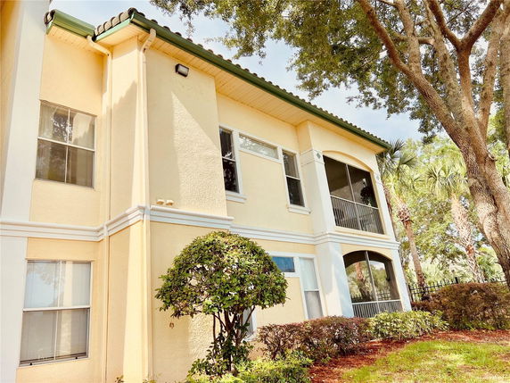 Front view of a two-story house with green roof tiles and beige exterior walls.
