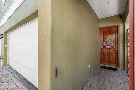 Front view of a house with a wooden main door and attached garage.