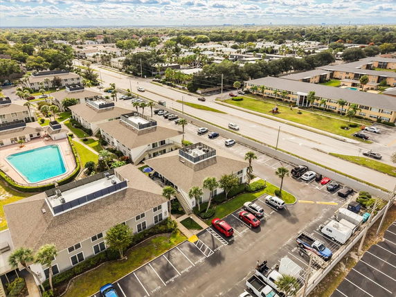 Aerial view of residential buildings with parking and a swimming pool.