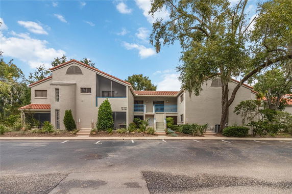 Front view of a multi-story building with a red-tiled roof and balconies.