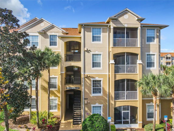 Front view of a multi-story apartment building with balconies and staircases.