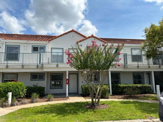 Front view of a two-story building with balconies and a tiled roof.