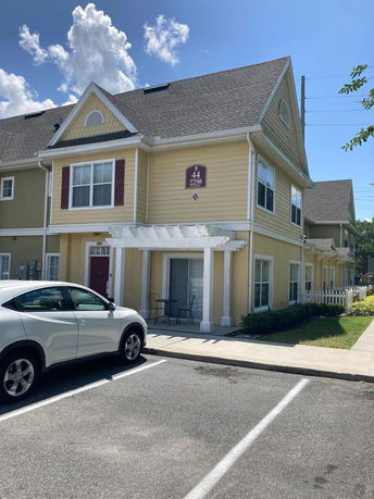 Front view of a two-story residential building with parking space.