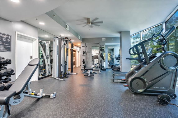 Indoor gym area with exercise equipment and large windows.