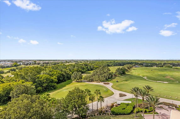 View of a golf course with trees and pathways in the surrounding area.
