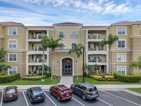 Front view of a multi-story residential building with parking area.