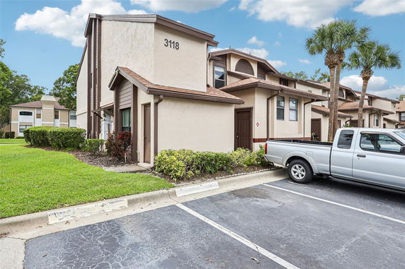 Front view of a two-story house with a parking area in front.