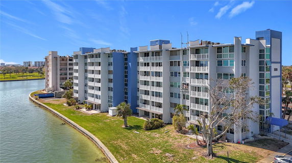 Front view of a multi-story apartment building by a water channel.