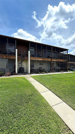 Front view of a two-story building with outdoor balconies and a spiral staircase.