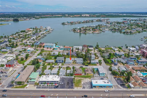 Aerial view of a residential area near a large body of water with multiple buildings and houses.