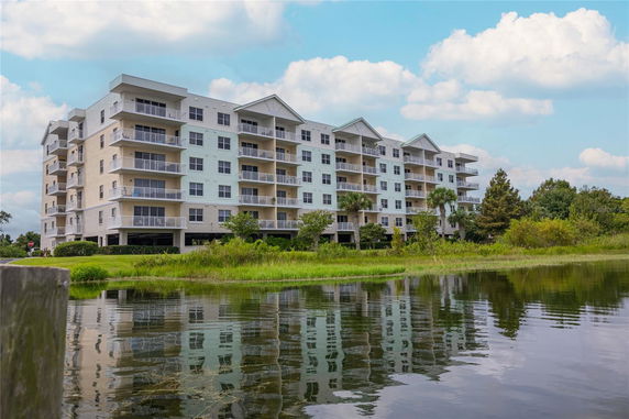 Front view of a multi-story apartment building near a body of water.