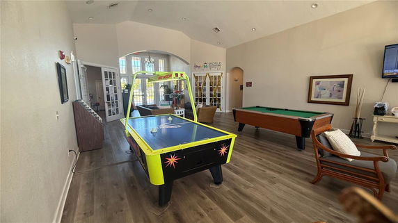 Interior view of a recreation room with air hockey and pool tables.