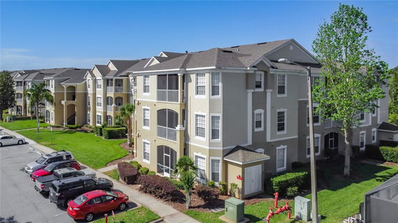 Front view of a multi-story apartment building with parking area.