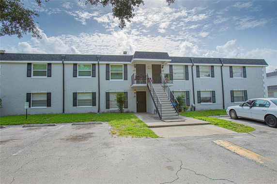 Front view of a two-story apartment building with an exterior staircase.