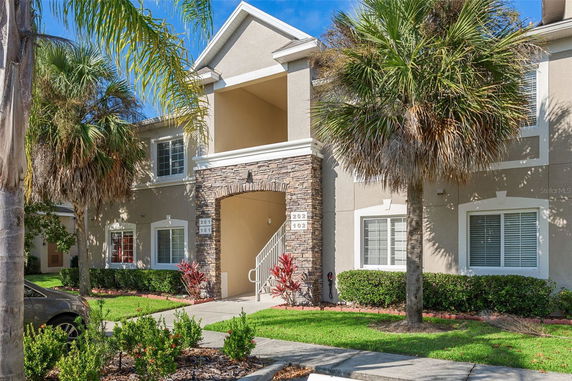 Front view of a two-story residential building with stone accents and a staircase.
