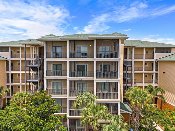 Front view of a multi-story residential building with balconies and green roofs.