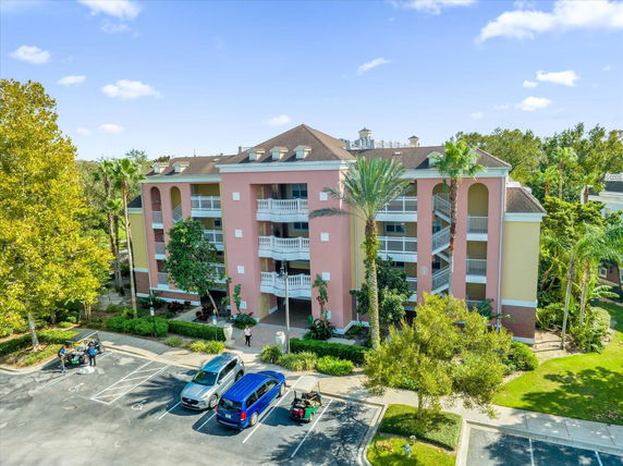 Front view of a multi-story building with a pink facade and multiple balconies.