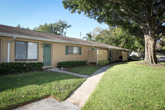 Front view of a single-story house with a green door and shutters.