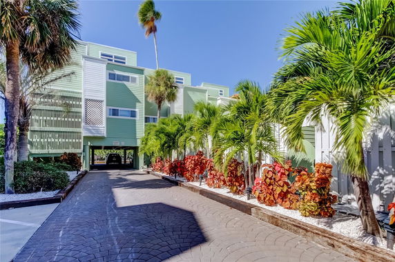 Front view of a multi-story building with light green exterior and multiple windows.
