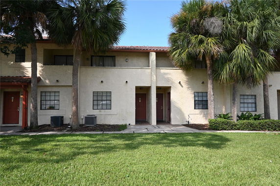 Front view of a two-story building with a red-tiled roof and multiple entrances.