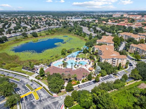 Panoramic view of a residential area with a swimming pool and a lake.