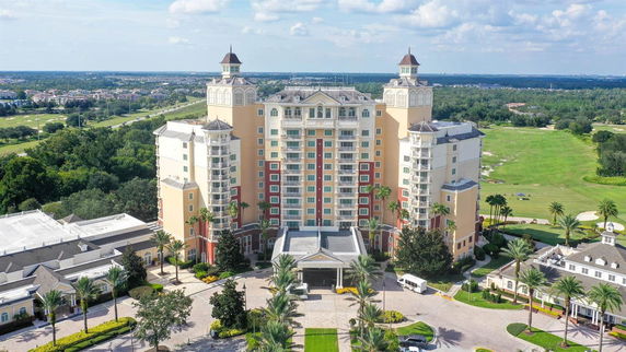 Front view of a tall multi-story building with decorative towers and a spacious entrance.