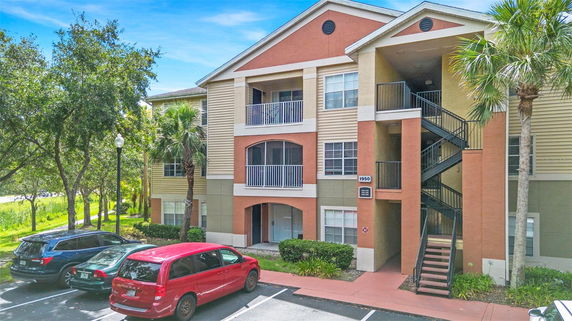 Front view of a multi-story residential building with exterior staircases and balconies.