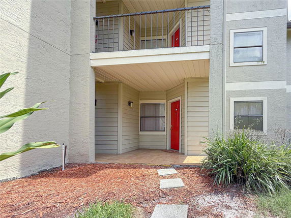 Front view of a house with a red door and a balcony.