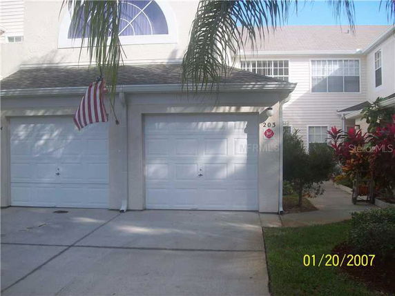 Front view of a building with two garages and upper-floor windows.