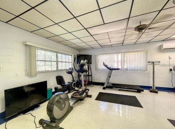Room with exercise equipment including a treadmill and stationary bike.