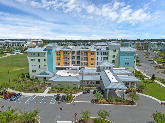 Front view of a multi-story building with colorful facade and a metal roof.