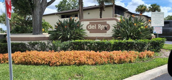 Front view of a building with a sign that reads 'del Rey' surrounded by landscaping.