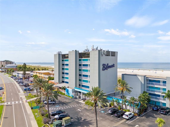 Front view of a multi-story beachfront building with parking area.
