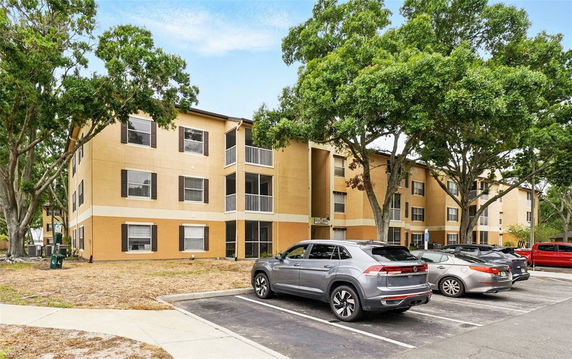 Front view of a three-story residential building with outdoor parking.