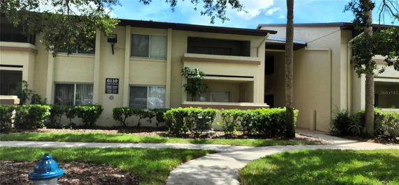 Front view of a two-story residential building with balconies and a walkway.