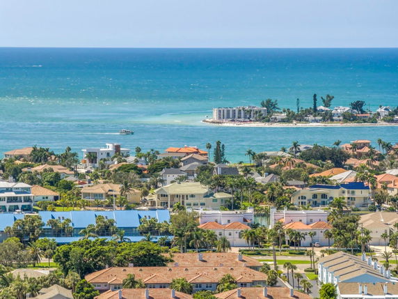 Panoramic view of a coastal residential area with ocean and buildings.