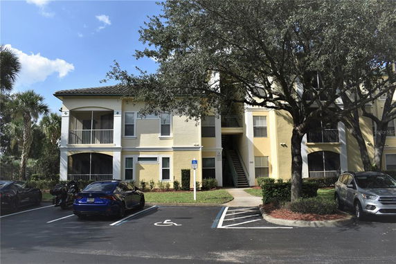 Front view of a multi-story residential building with attached parking area.