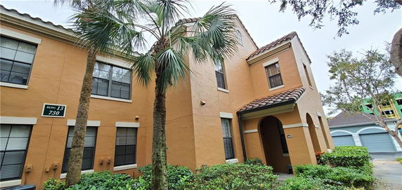 Front view of a two-story house with a tiled roof and multiple windows.