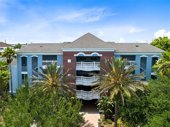 Front view of a multi-story building with a mix of brick and blue facade and balconies.