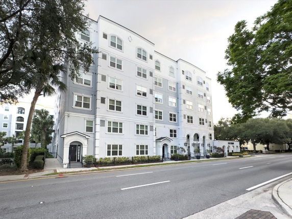 Front view of a multi-story apartment building with multiple windows and entrances.