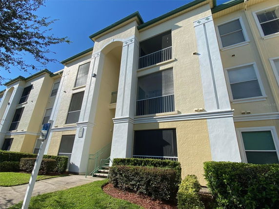 Front view of a multi-story apartment building with balconies and large windows.