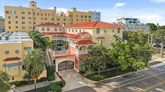 Front view of a multi-story building with a red-tile roof.