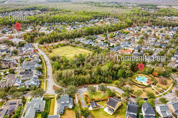 Aerial view of a residential neighborhood with a marked condo and community pool.
