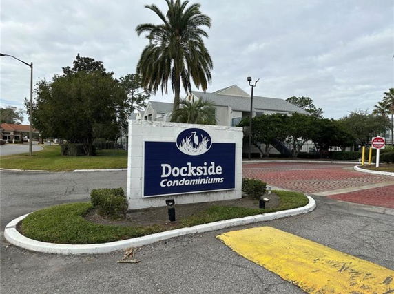 Front view of Dockside Condominiums with a prominent sign and surrounding greenery.