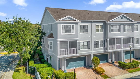 Front view of a three-story townhouse with a two-car garage and a screened balcony.